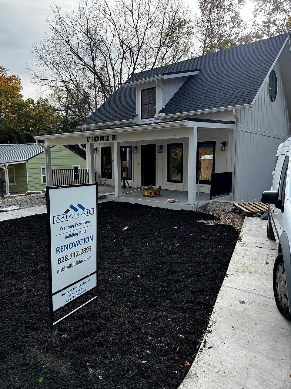 The finished porch with a Mikhail Builders renovation sign in the new front bed